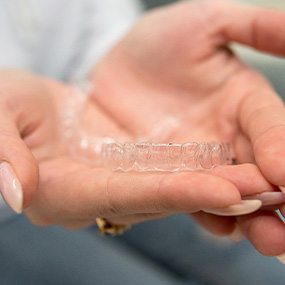 Closeup of patient holding clear aligner