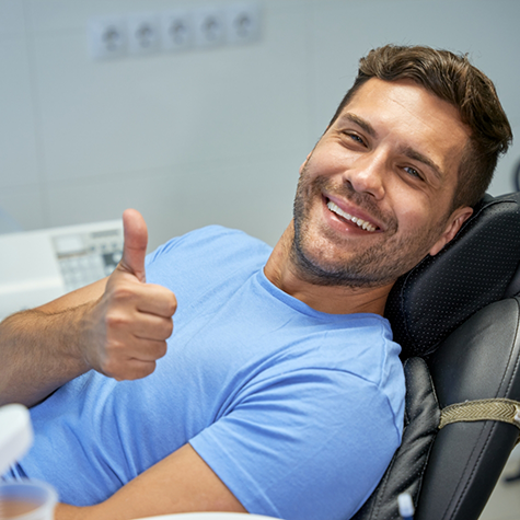 Man in the treatment chair smiling and giving a thumbs up