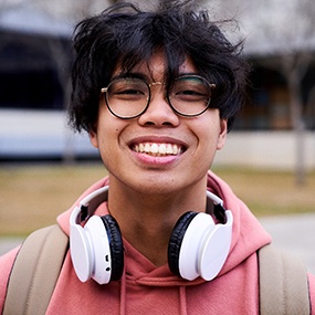 Closeup of teenage boy with black glasses smiling