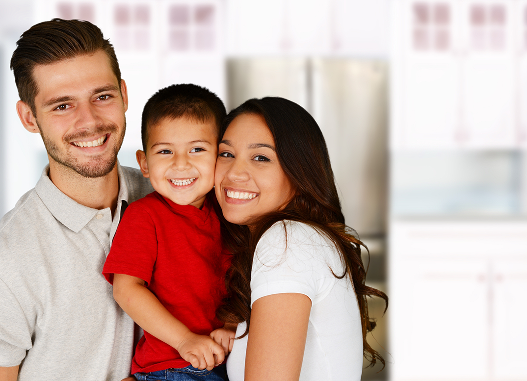 Family of three smiling at home