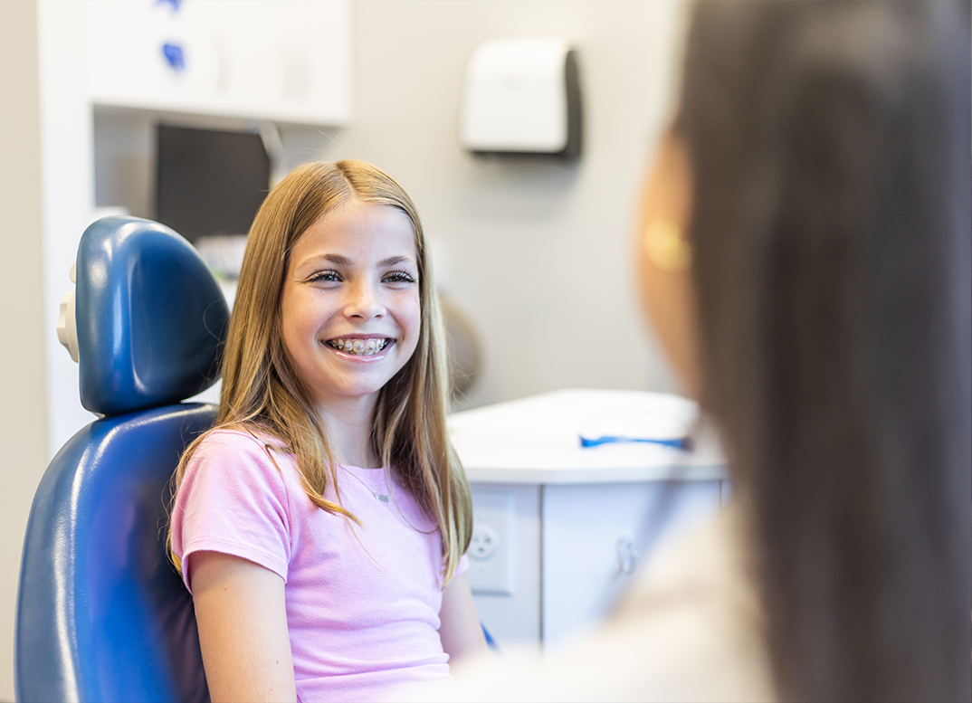 Young girl with braces grinning while visiting her orthodontic office in New England