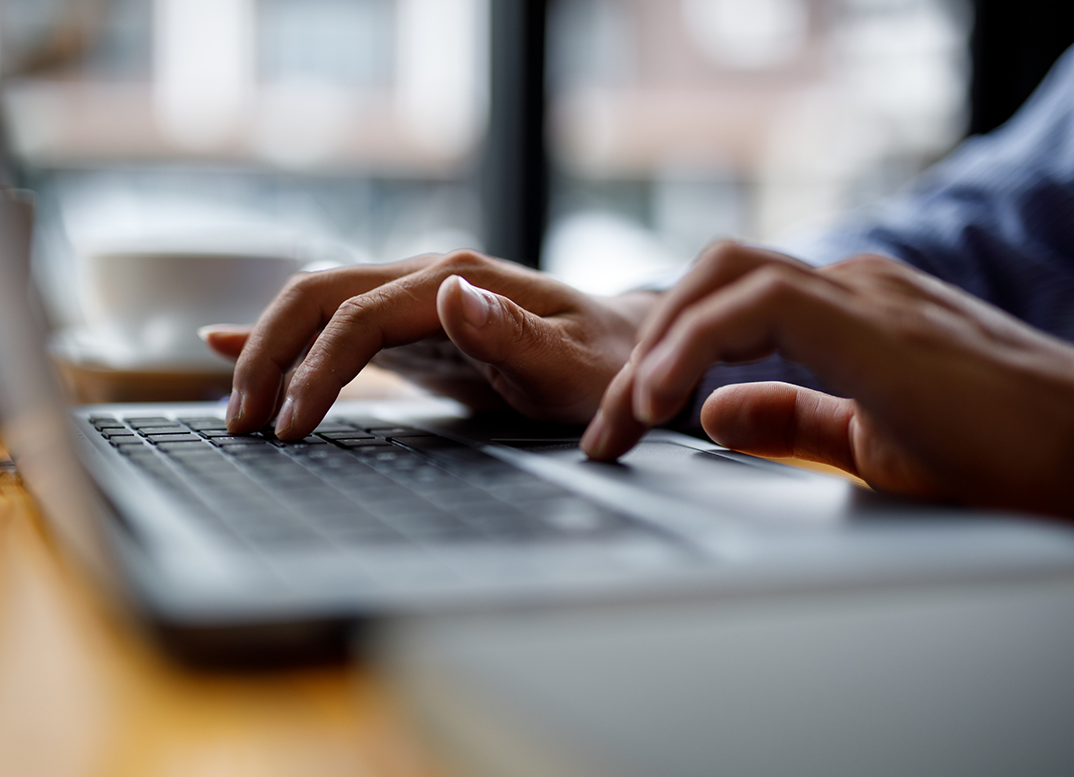 Close up of hands typing on a laptop