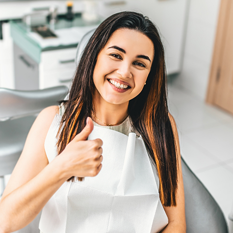 Smiling woman giving a thumbs up in the treatment chair