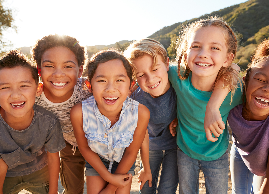 Group of kids smiling together in the sun