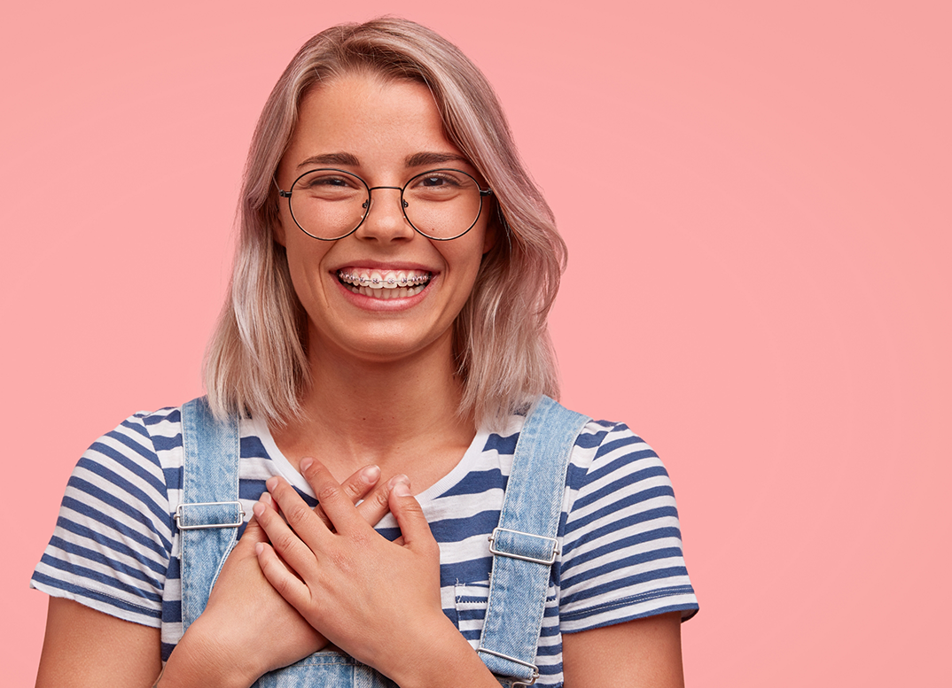 Blonde woman grinning with self-ligating braces in New England