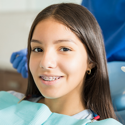 Teenage girl with braces sitting in the dental chair