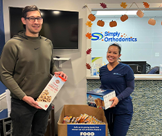 Two team members holding boxes of donated food