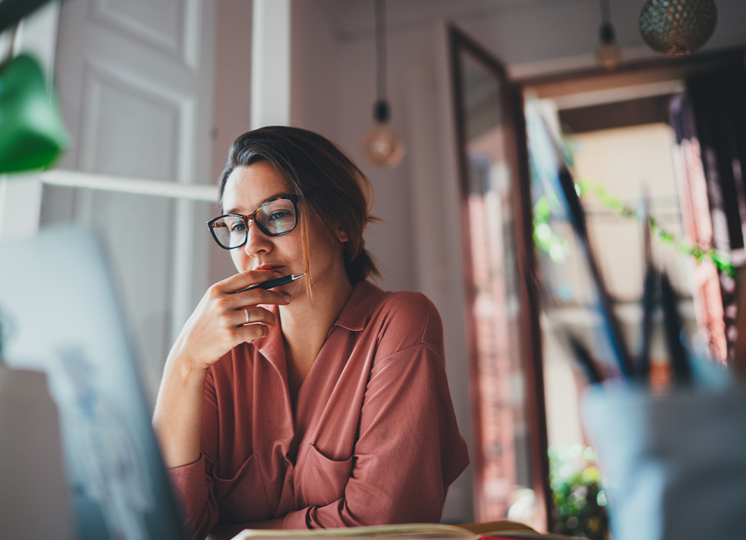 Woman sitting at a desk and looking at a computer