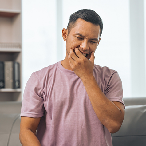 Man holding the sides of his face in pain